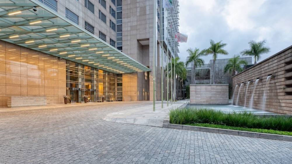 marquise de vidro da entrada principal do hotel, com o espelho d'água à direita